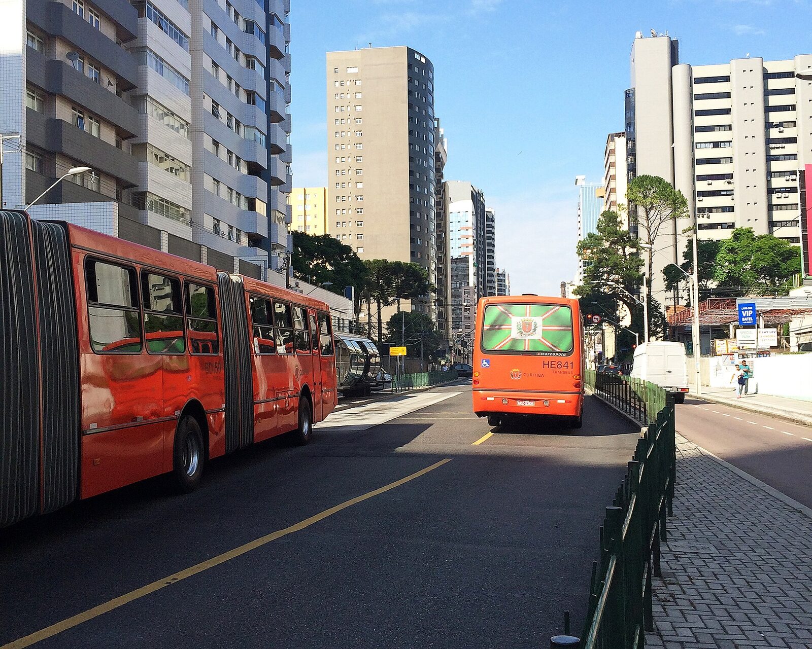 Estação-tubo e ônibus biarticulado vermelho em Curitiba