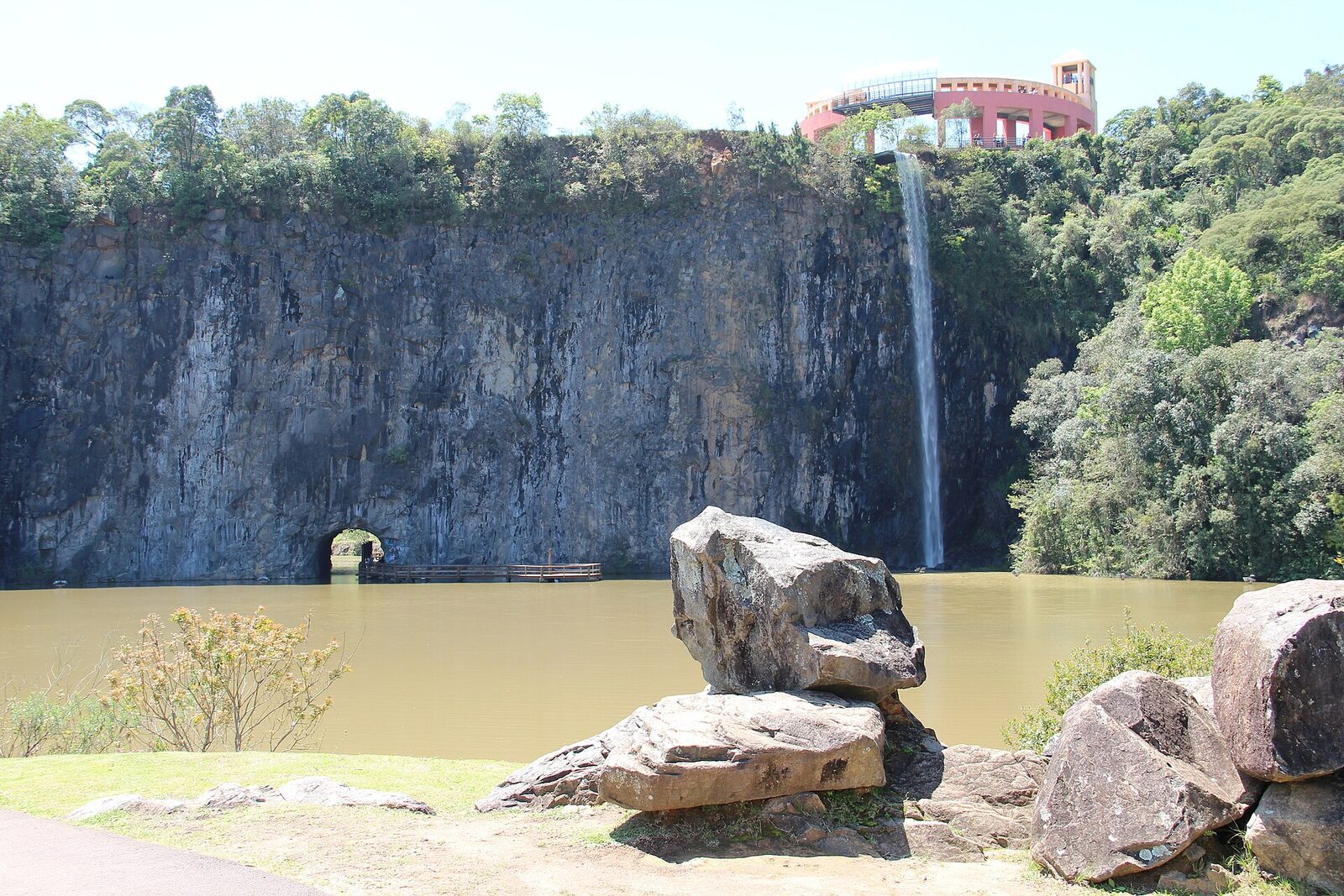 Paredão de pedra e cascata do Parque Tanguá, com o mirante no alto