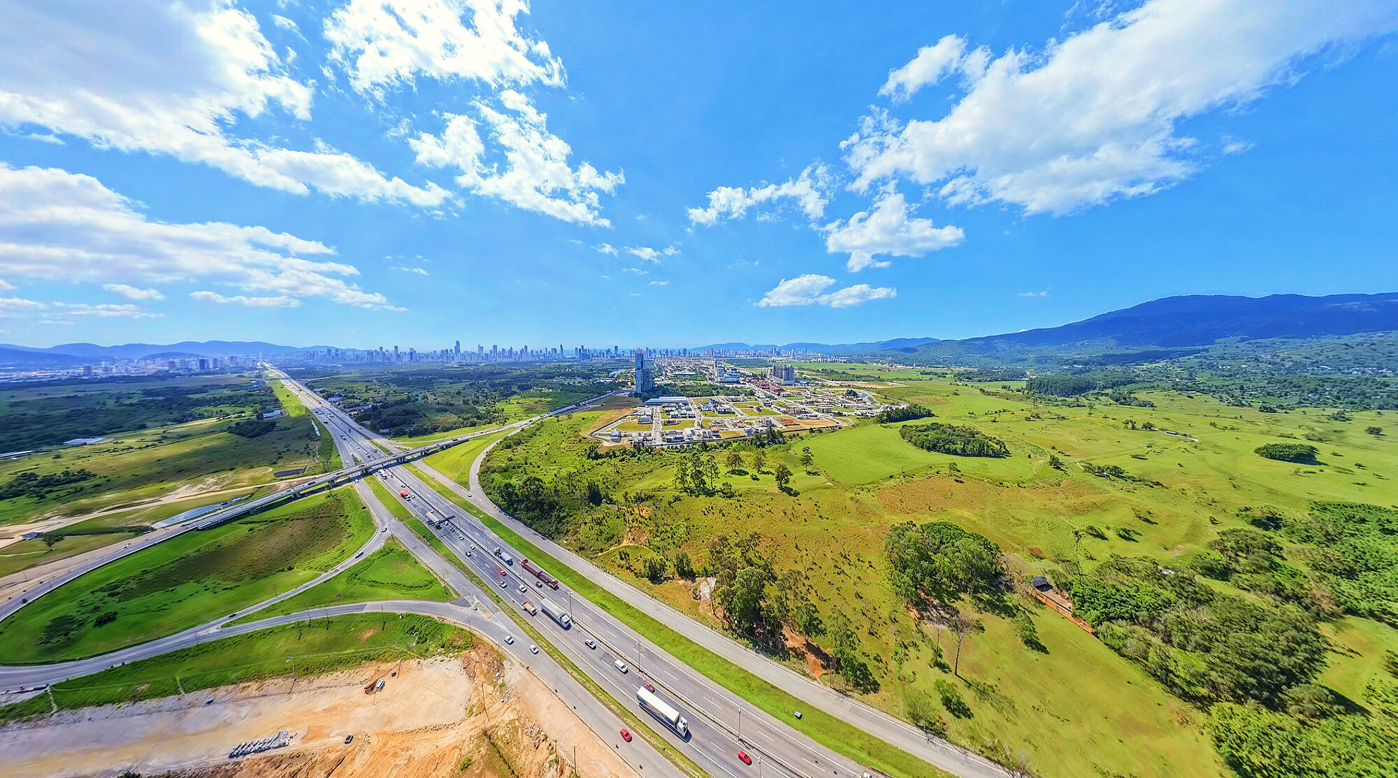 Trevo da BR-101 com o Vivapark ao fundo e o Perequê no horizonte, setembro de 2026