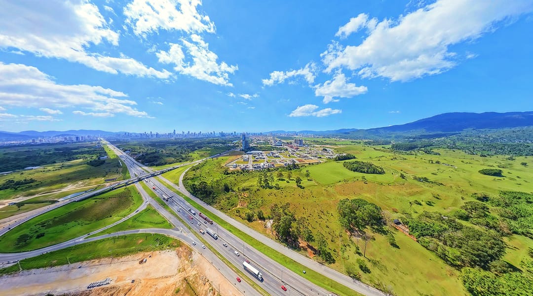 Trevo da BR-101 com o Vivapark ao fundo e o Perequê no horizonte, setembro de 2026