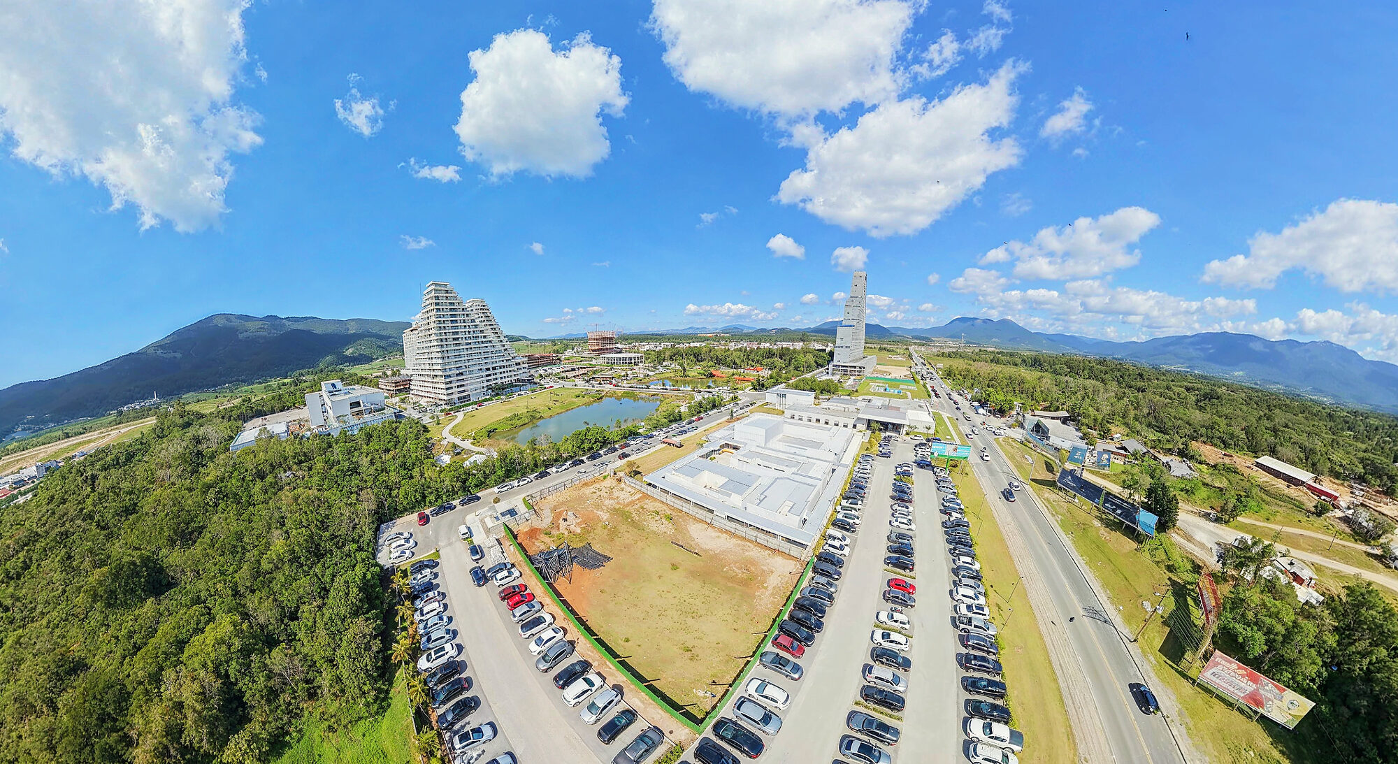 Central de vendas do Vivapark em setembro de 2026, com o estacionamento cheio e o Vértice ao fundo