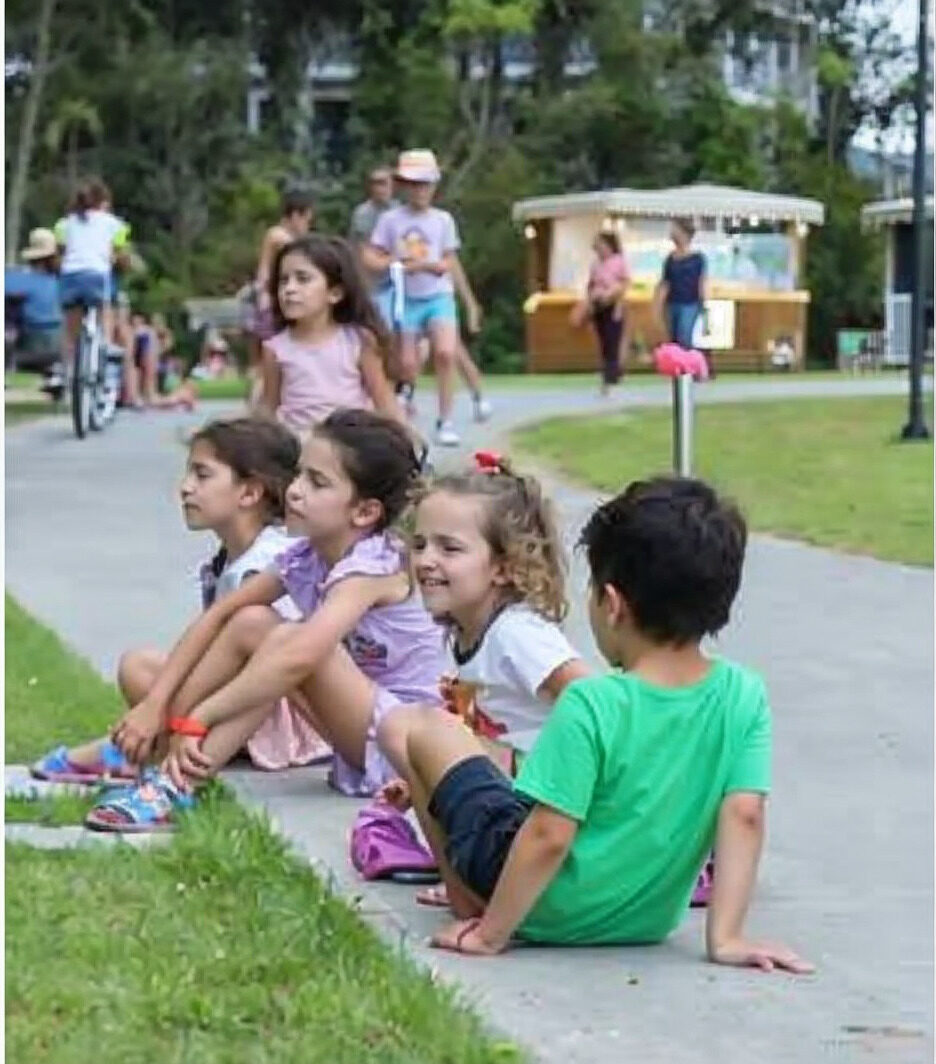 Children sitting on the edge of the Vivapark park lawn
