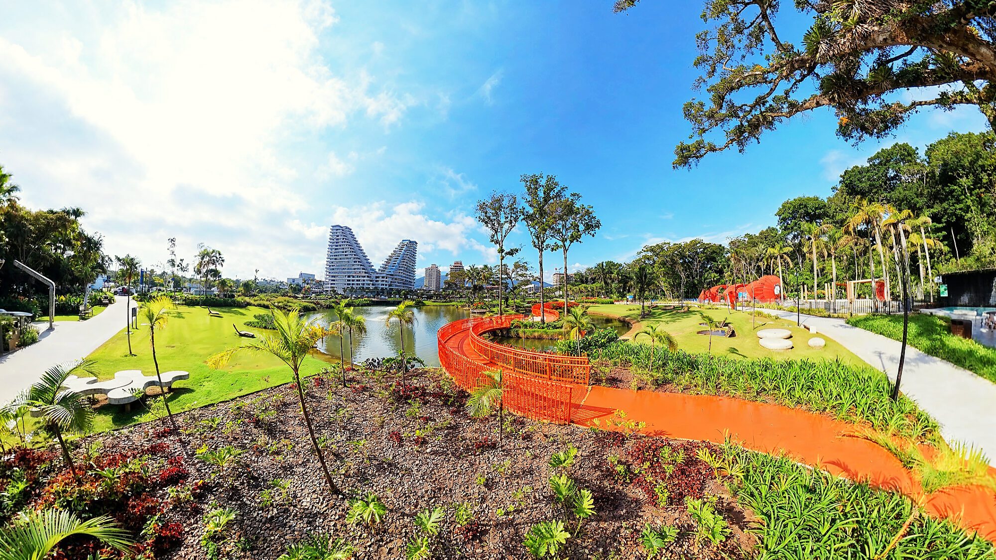 Parque Viva Energia do Vivapark em setembro de 2026: o lago, a passarela laranja e o Vértice ao fundo